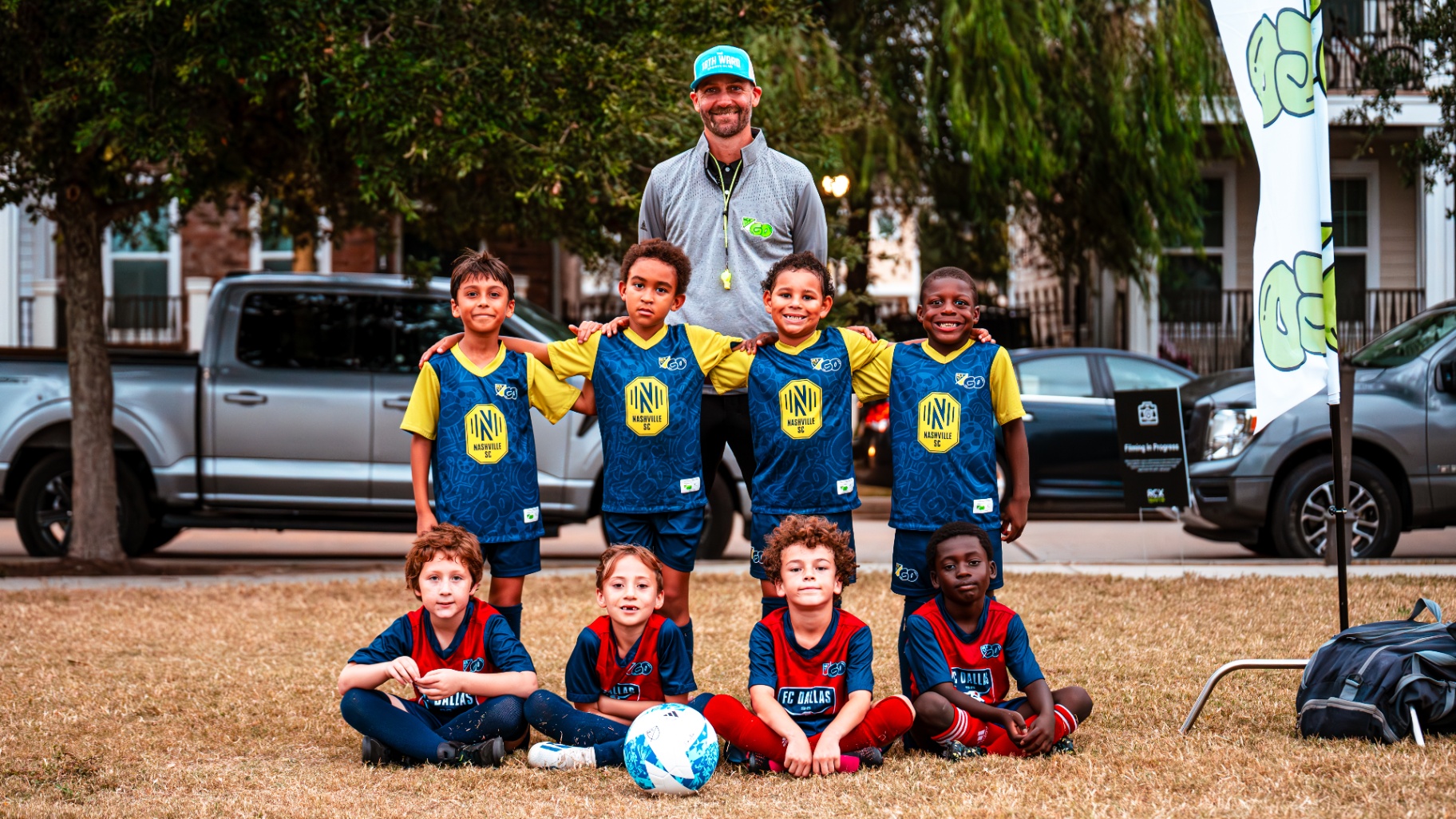 Full team photo with coach at an MLS GO event