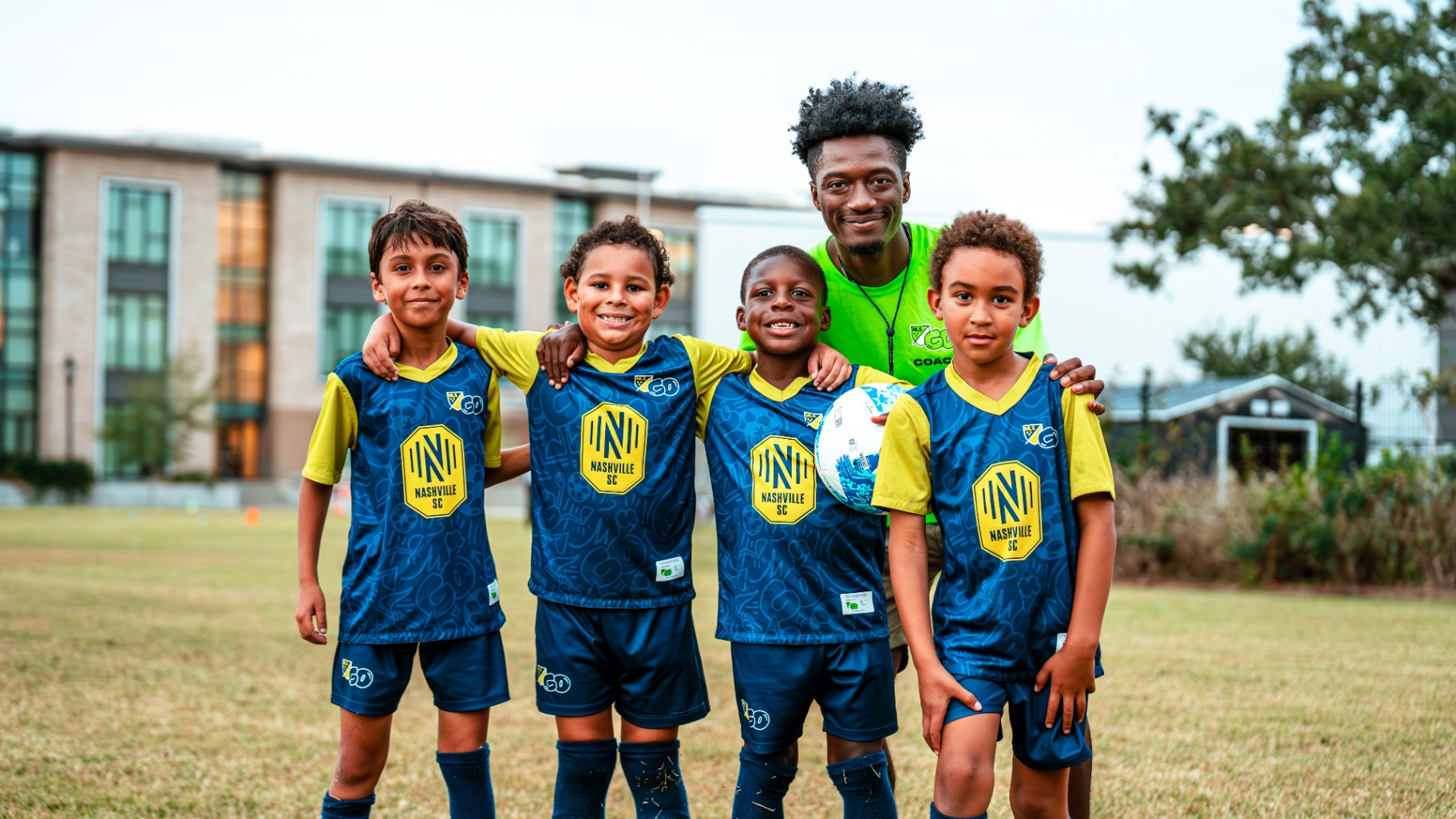 Volunteer coach with a smiling youth soccer team