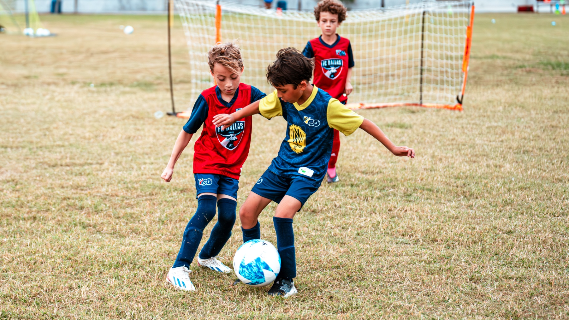 Two young players competing for the ball